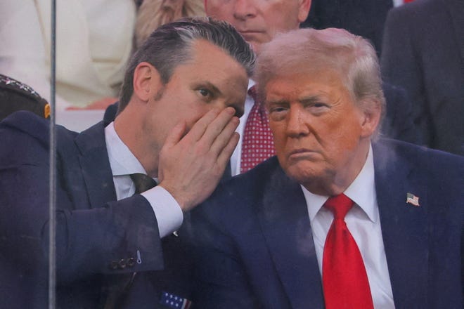Defense Secretary Pete Hegseth talks to President Donald Trump during the U.S. Army's 250th birthday parade in Washington, DC, on June 14, 2025.